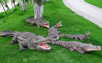 公園草地上擺放的形態(tài)各異的玻璃鋼仿真動物鱷魚雕塑